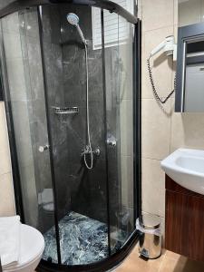 una ducha con puerta de cristal en un baño en Nova Roma Hotel, en Estambul