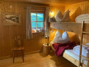 a bedroom with two bunk beds and a window at Selbstversorgerhaus Herisch in Schladming