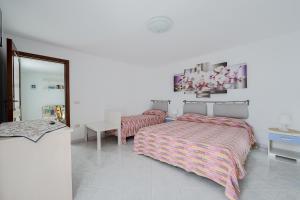 1 dormitorio con 2 camas, mesa y espejo en Torre di Amalfi - holiday house, en Amalfi