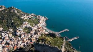 a cross on the side of a mountain next to the ocean at Torre di Amalfi - holiday house in Amalfi