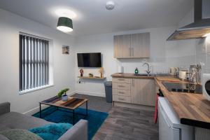 a kitchen and living room with a couch and a table at Bank Street Apartment 4 in Blackpool