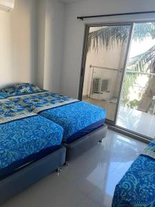 - une chambre avec 2 lits et une grande fenêtre dans l'établissement Apartamento en el epicentro del Carnaval, à Barranquilla