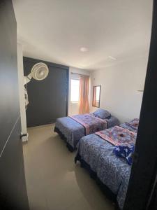 a hotel room with two beds and a window at Apartamento en el epicentro del Carnaval in Barranquilla