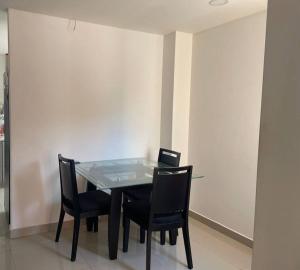 - une table à manger avec des chaises et un ordinateur portable dans l'établissement Apartamento en el epicentro del Carnaval, à Barranquilla