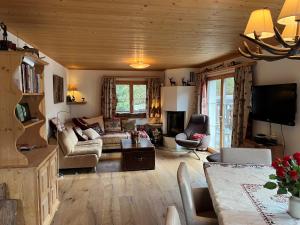 a living room with a couch and a tv at Gäuggeliweg 36, Klosters in Klosters