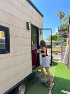 a woman standing on a skateboard outside of a trailer at Roger's Hostel Tel Aviv (age 18-45) in Tel Aviv