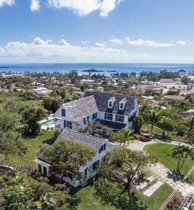 an aerial view of a house with the ocean in the background at Buccaneer Hill Cottage cottage in Governorʼs Harbour