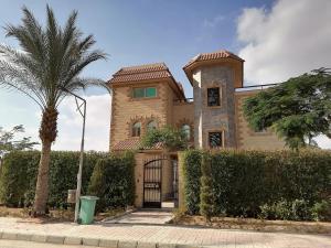 une maison avec un palmier en face dans l'établissement Solaimania Resort منتجع السليمانية, à Giza