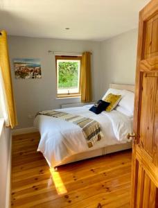 a bedroom with a large bed with a window at Beautiful Riverside Retreat in Blackwater, Wexford in Blackwater