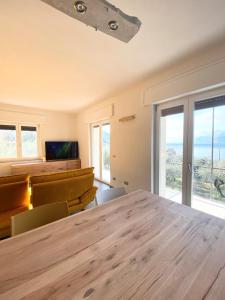 Un comedor con mesa y sillas y ventanas. en Cochetto's House in Malcesine, en Malcesine