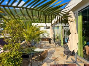 a patio with a table and chairs and an umbrella at Hotel Medoviy in Gagra