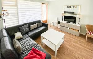 - un salon avec un canapé noir et une table blanche dans l'établissement Cozy Apartment In Zoutelande With Wifi, à Zoutelande