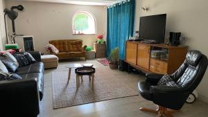 a living room with a couch and a tv at Le Gîte de Pomme in Nargis
