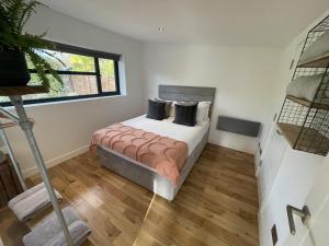a bedroom with a bed and a window at River guest house with jacuzzi fire and boat hire in Staines