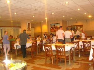 een groep mensen die rond een restaurant met tafels staan bij New Pola Hotel in Luxor