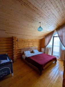 1 dormitorio con 1 cama en una habitación de madera en LOG HOUSE, en Bakuriani