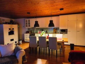 uma cozinha com mesa e cadeiras e uma cozinha com armários brancos em Villa Tiiro em Ii