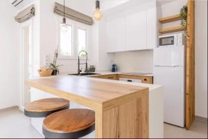 eine Küche mit einer Holzterrasse mit zwei Holzhockern in der Unterkunft Casa Marina Moraira in Moraira
