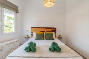 ein Schlafzimmer mit einem Bett mit grünen Handtüchern darauf in der Unterkunft Casa Marina Moraira in Moraira