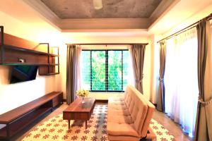 - un salon avec un canapé, une table et une fenêtre dans l'établissement Thean y apartment, à Siem Reap