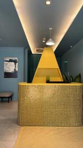 a lobby with a yellow counter in a room at The Assembly Place, Hotel at Veerasamy in Singapore