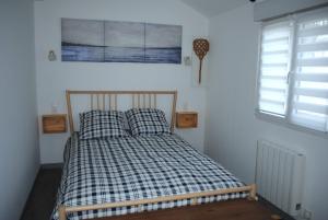 ein Bett mit zwei Kissen in einem Zimmer mit einem Fenster in der Unterkunft Le Clos de la Marquise in Amboise