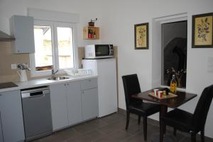 una pequeña cocina con mesa y microondas en Le Clos de la Marquise, en Amboise