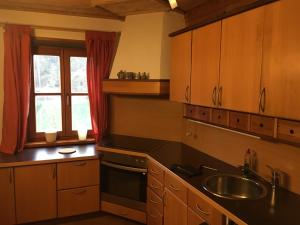a kitchen with wooden cabinets and a sink and a window at Schreiner in Wernstein am Inn