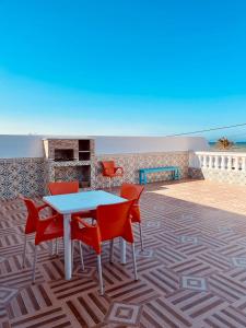 un tavolo e sedie su un patio con vista sull'oceano di DAR HIDOUS a Al Māʼīyah