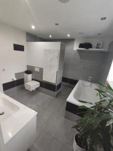 La salle de bains est pourvue de 2 lavabos et d'une baignoire. dans l'établissement Bungalow mit 200 qm Wohnfläche :), à Birgland