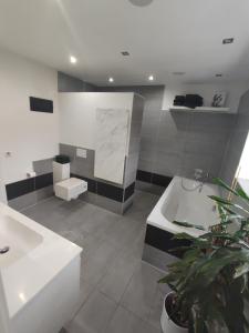 a bathroom with two sinks and a bath tub at Bungalow mit 200 qm Wohnfläche :) in Birgland +16 photos