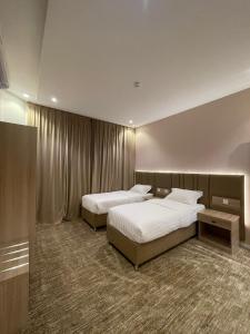 قمم بارك 3 Qimam Park Hotel في أبها: غرفه فندقيه سريرين في غرفه