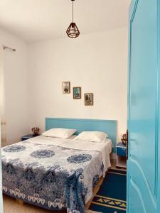 a bedroom with a bed with a blue head board at DAR HIDOUS in Al Māʼīyah