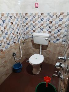 Omkar Beach Resort في مالفان: حمام به مرحاض وجدار بلاط كلب
