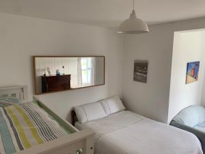 um pequeno quarto com 2 camas e um espelho em Stunning Cottage on the Beach Portnoo Narin em Portnoo