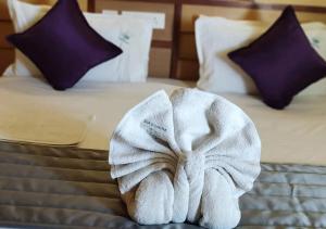 a white towel sitting on top of a bed at Hotel Aishwaryaa in Erode +48 photos