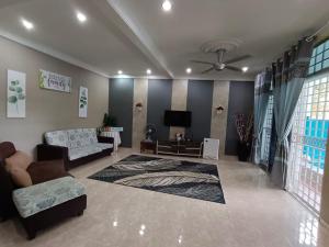 ein Wohnzimmer mit einem Sofa und einem TV in der Unterkunft D'Diana Homestay in Port Dickson