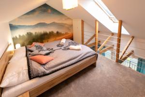 a bedroom with a bed with a painting on the wall at Apartamenty Słoneczna Góra w spokojnej okolicy - Dream Apart in Szczyrk