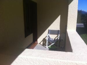 a chair sitting in the shade of a building at appartement ski au pied in Valmorel