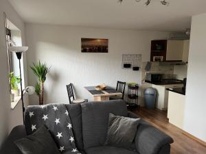 ein Wohnzimmer mit einem grauen Sofa und einem Tisch in der Unterkunft Ferienwohnung Eickwinkel in Winterberg