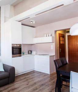 a kitchen and dining room with white cabinets and a table at Apartament Matilena in Świnoujście