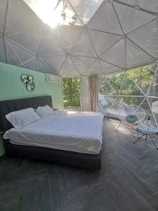 ein Schlafzimmer mit einem großen Bett in einem Zelt in der Unterkunft Roble Coral Glamping in Sarapiquí