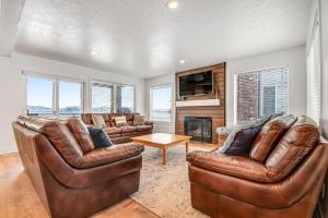 a living room with two leather chairs and a fireplace at Harbor Village Retreat in Garden City