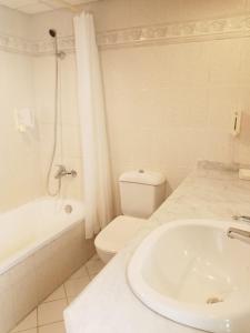 a white bathroom with a sink and a toilet at Tobya Village Hotel in Taba