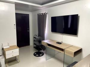 a room with a desk and a television on a wall at 4 - Affordable 2-Storey House in Cabanatuan City in Cabanatuan