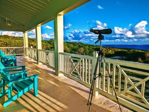 a camera on a porch with a view of the ocean at Sephora House home in Gregory Town
