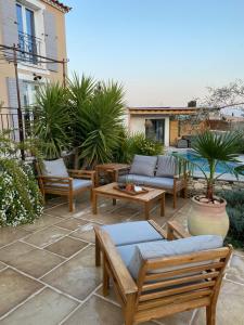 a patio with couches and tables and plants at le pool house in Nîmes