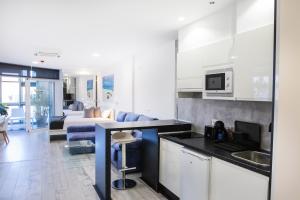 a kitchen and a living room with a couch at Coccoloba Suites Corralejo in Corralejo