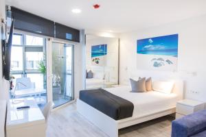 um quarto com uma cama e um quarto com uma secretária em Coccoloba Suites Corralejo em Corralejo