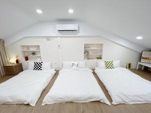 a room with three beds in a attic at Soda White Tainan Homestay in Tainan